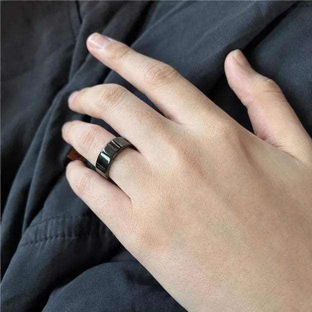 A hand wearing the black Quriov Smart Ring, relaxed in a soft sweater.